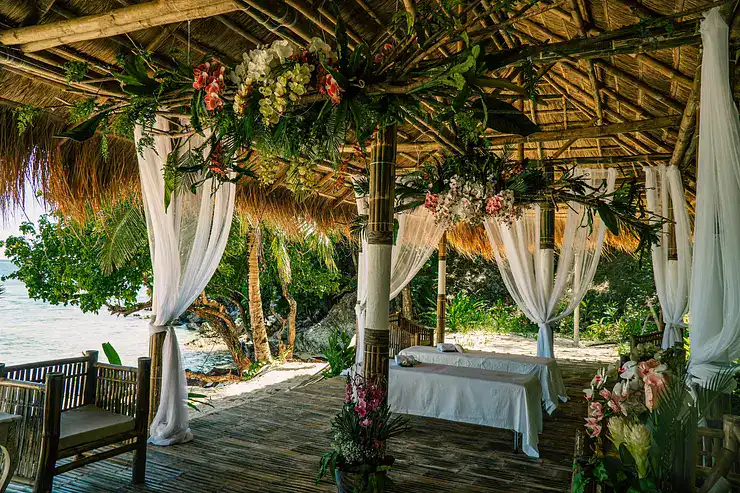 Idyllic tropical gazebo with floral decor overlooking the sea.