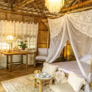 Charming bamboo bedroom with lace canopy, wooden furniture, and tropical accents for a serene stay.