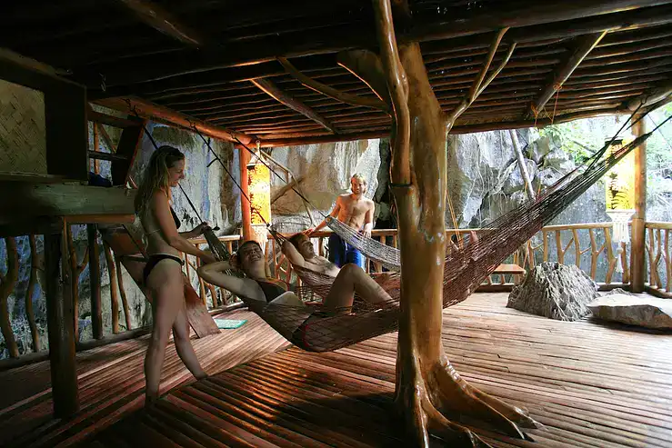 Relaxing hammock lounge surrounded by nature and rustic wooden decor.