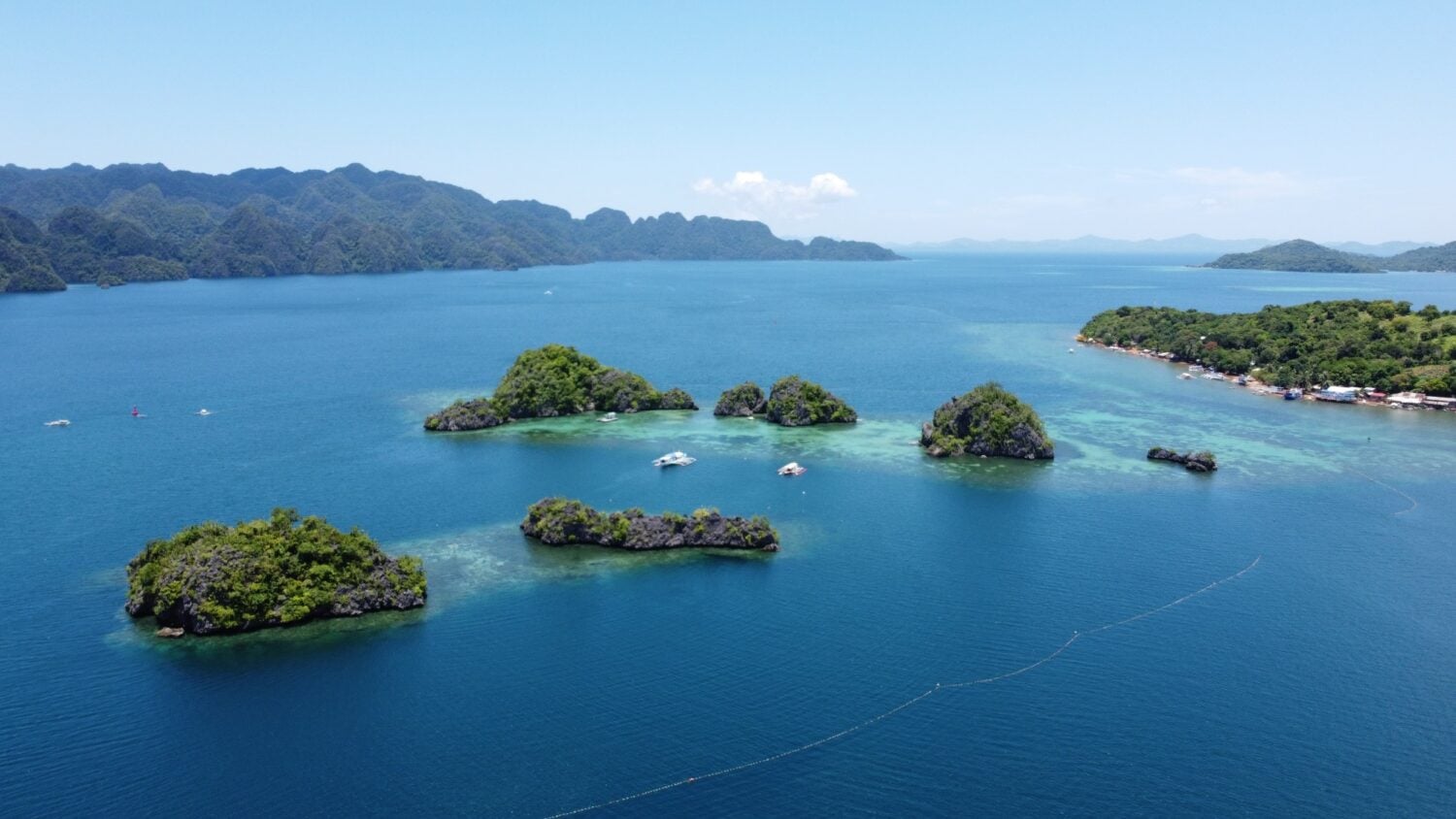 Stunning aerial view of lush islands and clear blue waters in the Philippines.