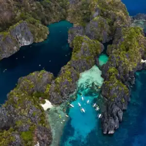 Aerial view of limestone cliffs and crystal-clear waters in a Philippine island paradise.