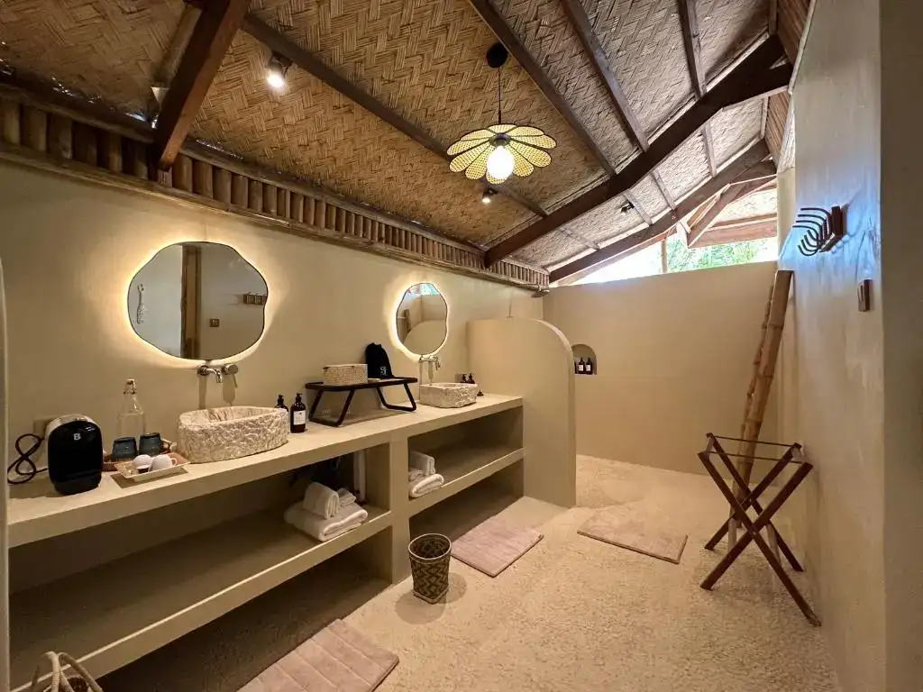 Spacious bathroom featuring bamboo ceiling, round mirrors, and eco-friendly design in Philippines.