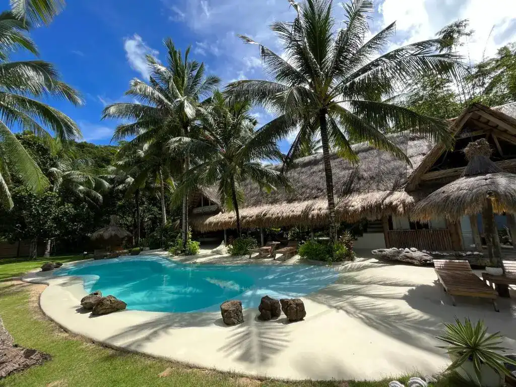 Relaxing pool nestled among lush palm trees on a tropical island in the Philippines.