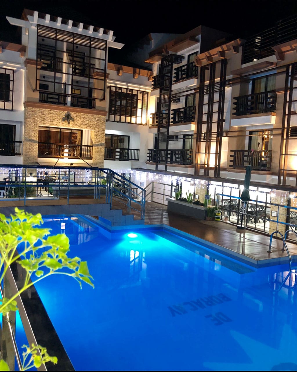 Bright nighttime view of a stylish hotel pool with inviting blue water.