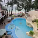 Bright, inviting pool scene overlooking the beach and lush greenery in the Philippines.