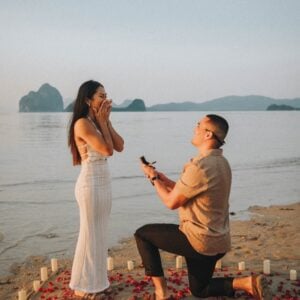 El Nido wedding proposal with a man proposing to a woman on the beach at sunset.