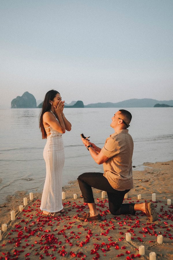 El Nido wedding proposal with a man proposing to a woman on the beach at sunset.