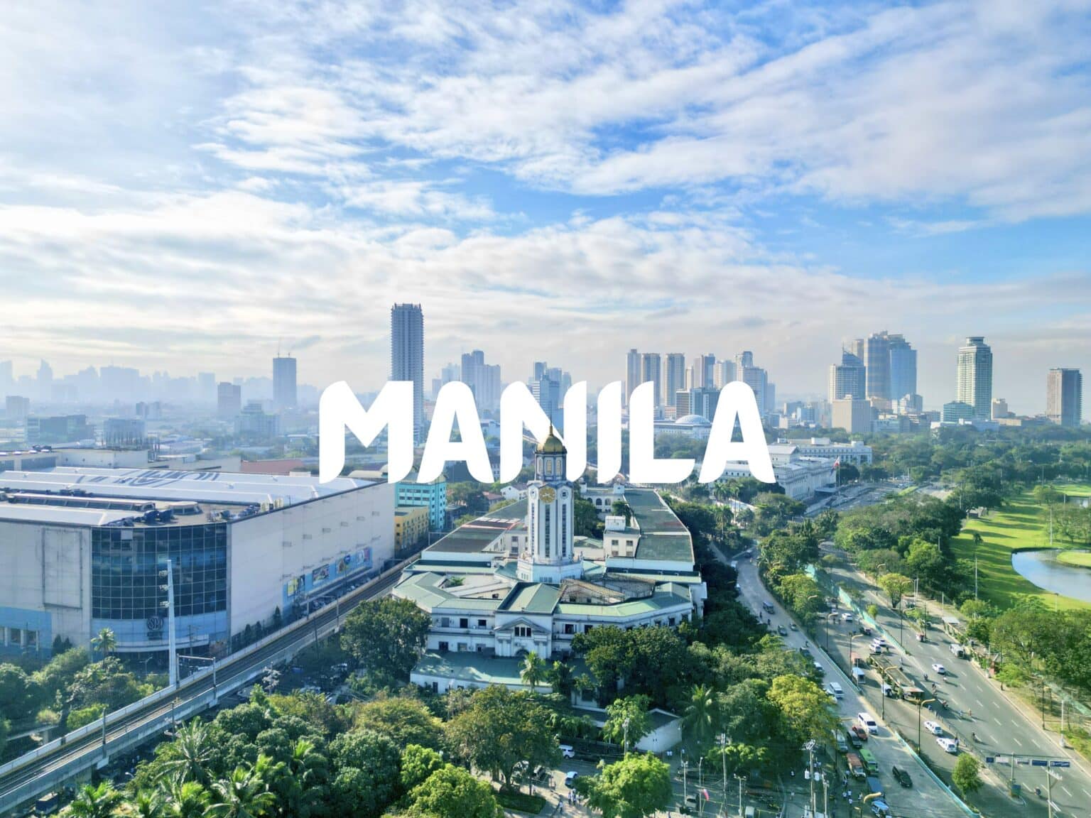 Bright city view of Manila, Philippines featuring high-rise buildings, lush parks, and a vibrant urban landscape.