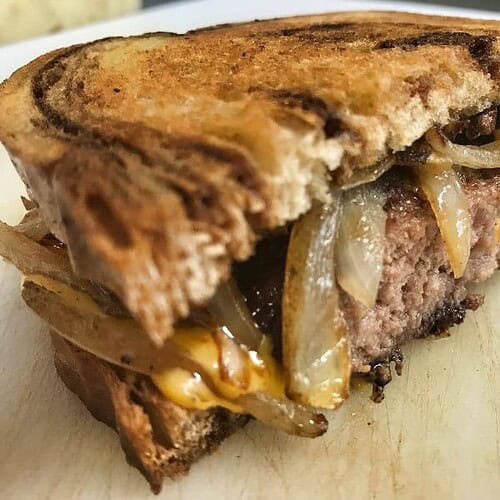 Crispy grilled sandwich with melted cheese and caramelized onions, savory comfort food.