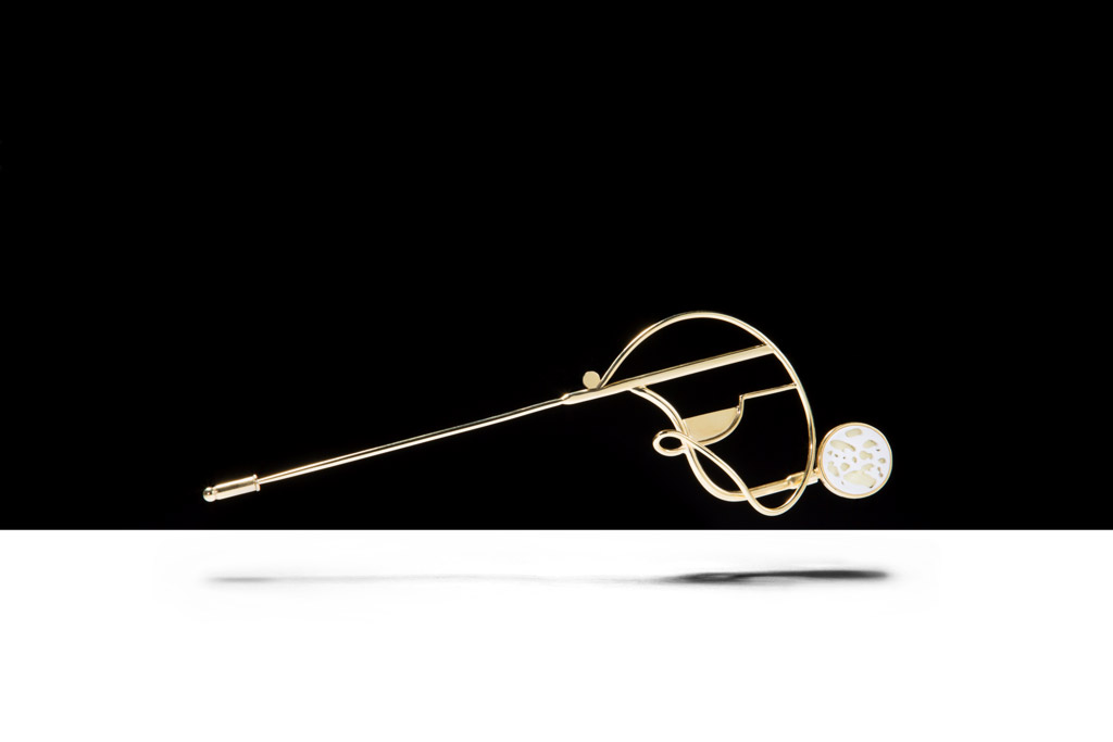 a gold brooch with a golf ball on it