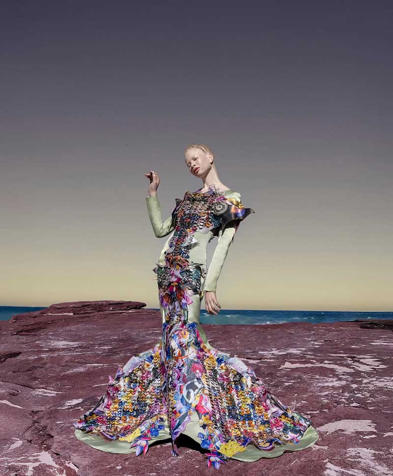 a woman in a colorful dress standing on a rock
