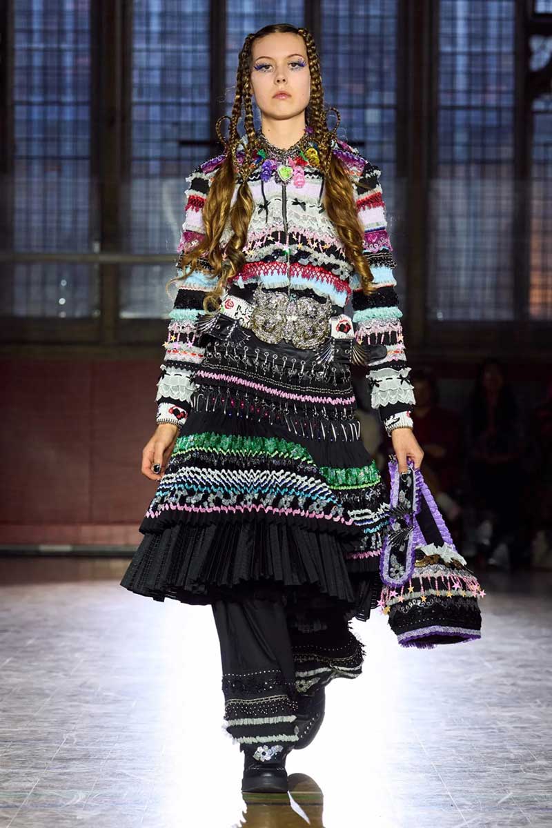 a model walks down the runway in a colorful dress