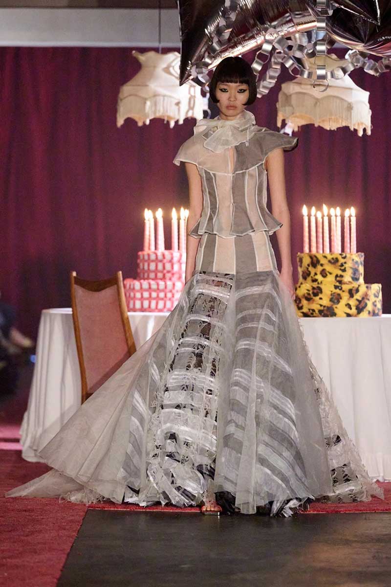 a woman walking down a runway in a dress