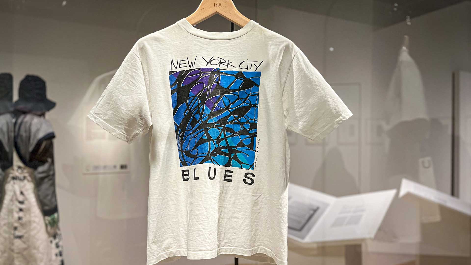 a t - shirt hanging on a rack in a museum