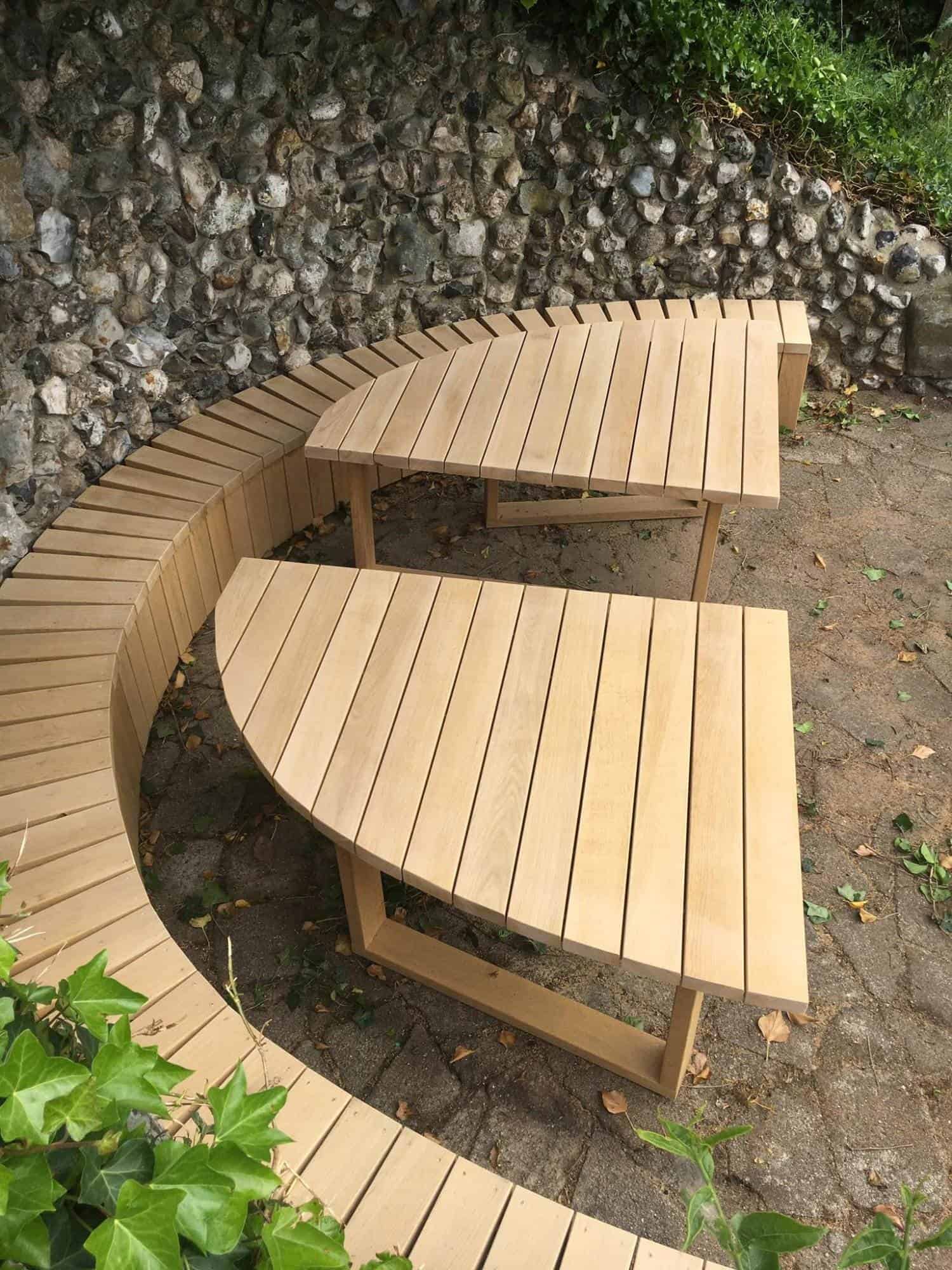 Hjørnebænk i træ til udendørs have eller terrasse, designet til komfort og holdbarhed.