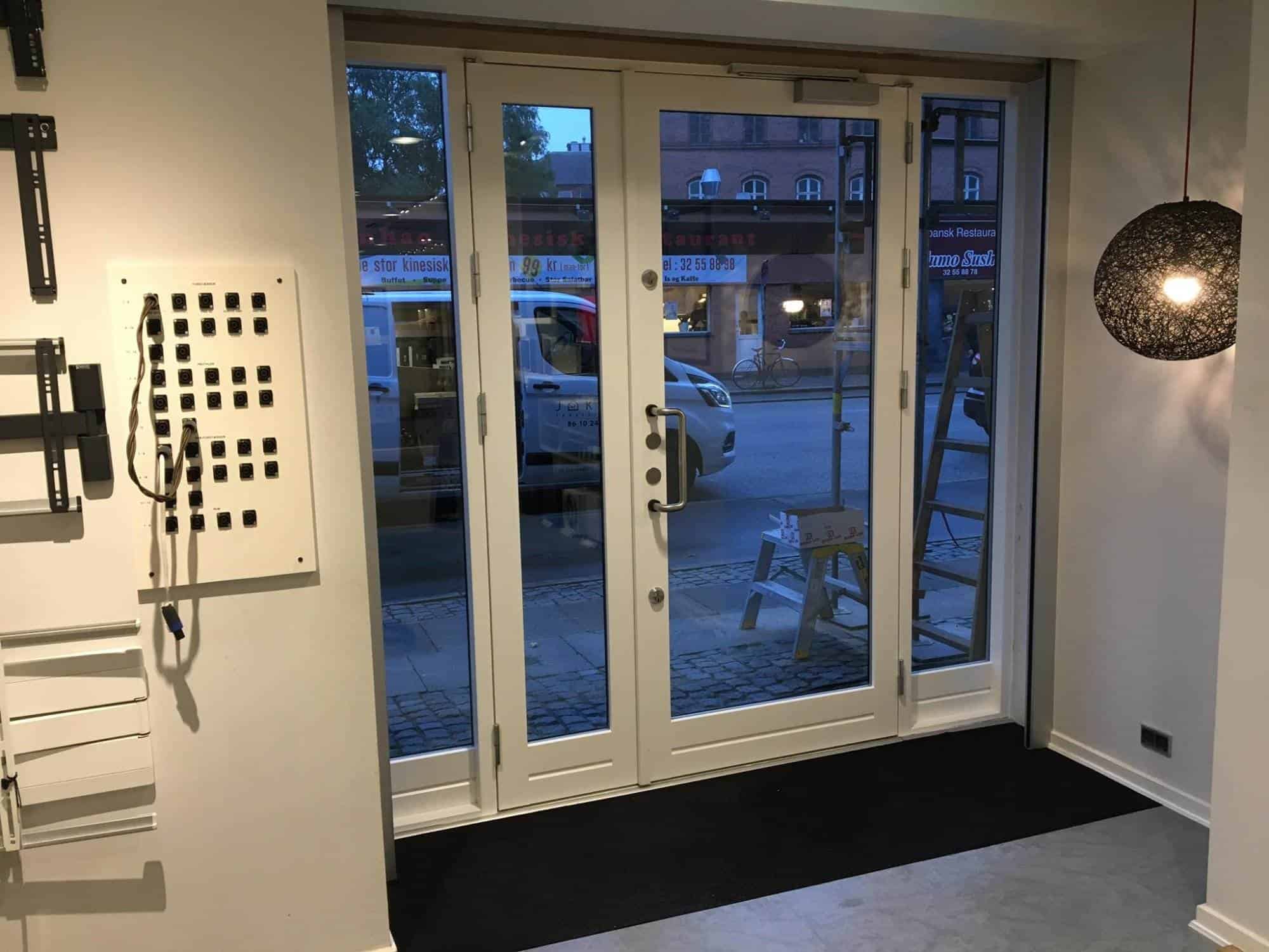 Glasdør til butik med store vinduer og moderne design.