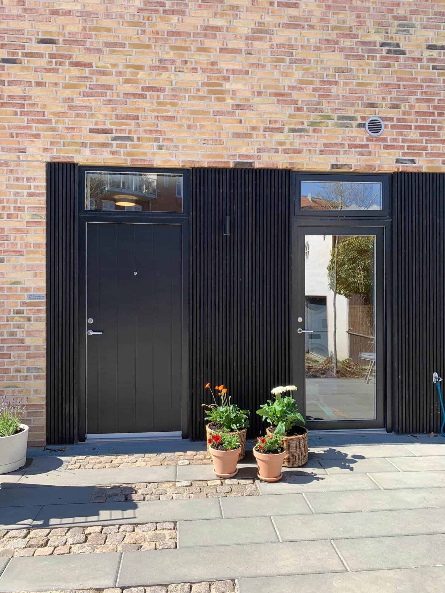Nyudført dør- og vinduesinstallation med sort træbeklædning.
