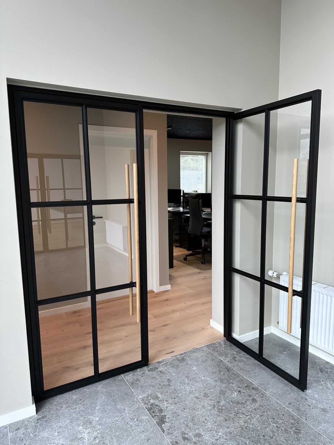 Glasdøre med sort ramme til kontor, skaber åbent og lyst arbejdsmiljø.