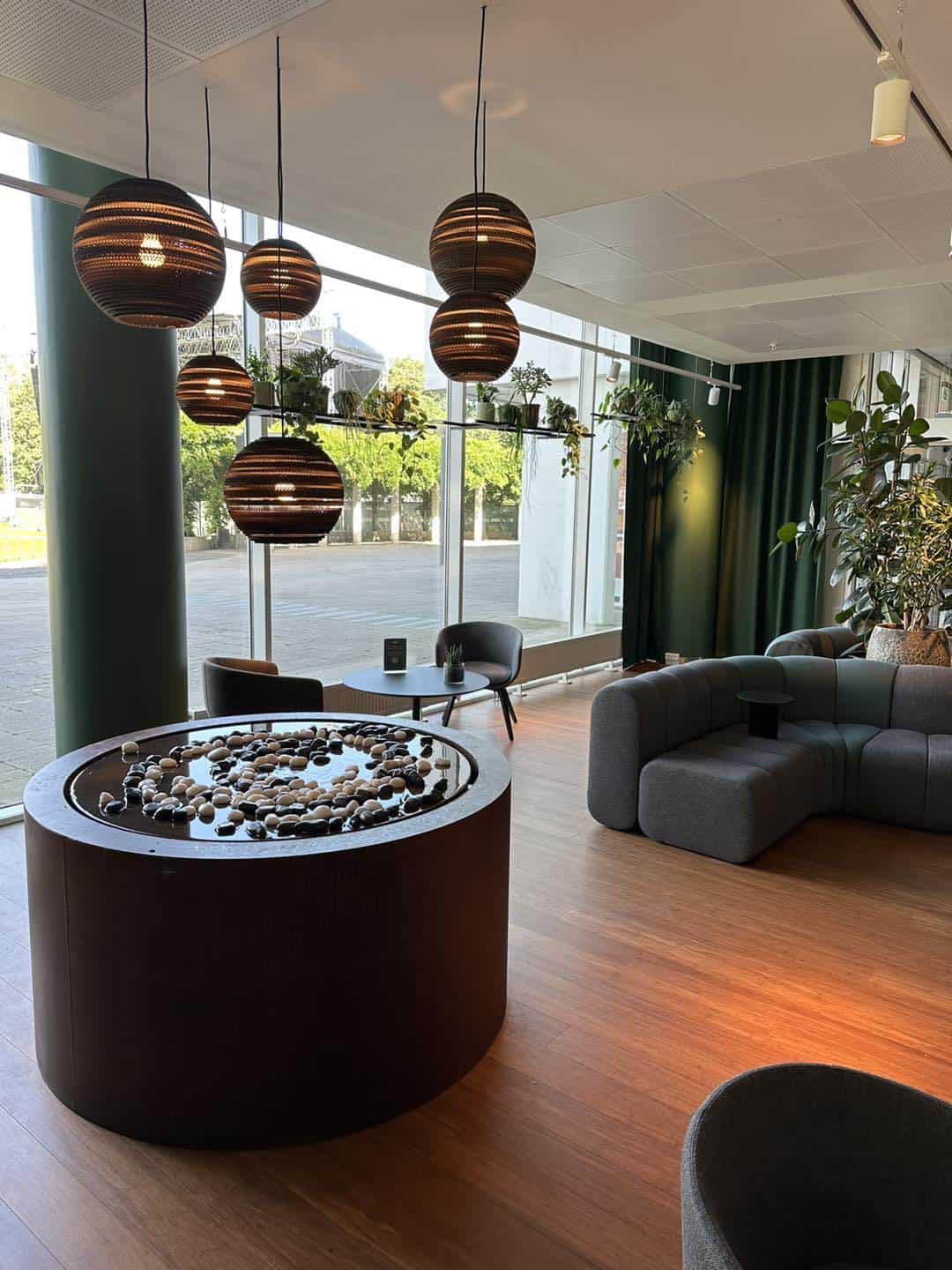 Moderne hotelindretning med store vinduer og komfortable siddepladser, perfekt til afslapning og soc.