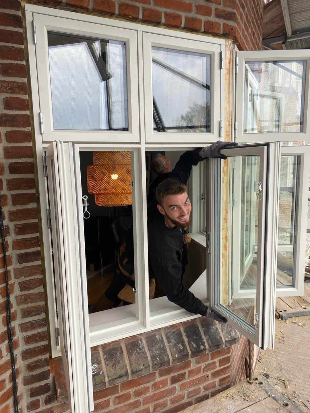 Mand installerer nye vinduer i en ældre murstensbygning i Aarhus.