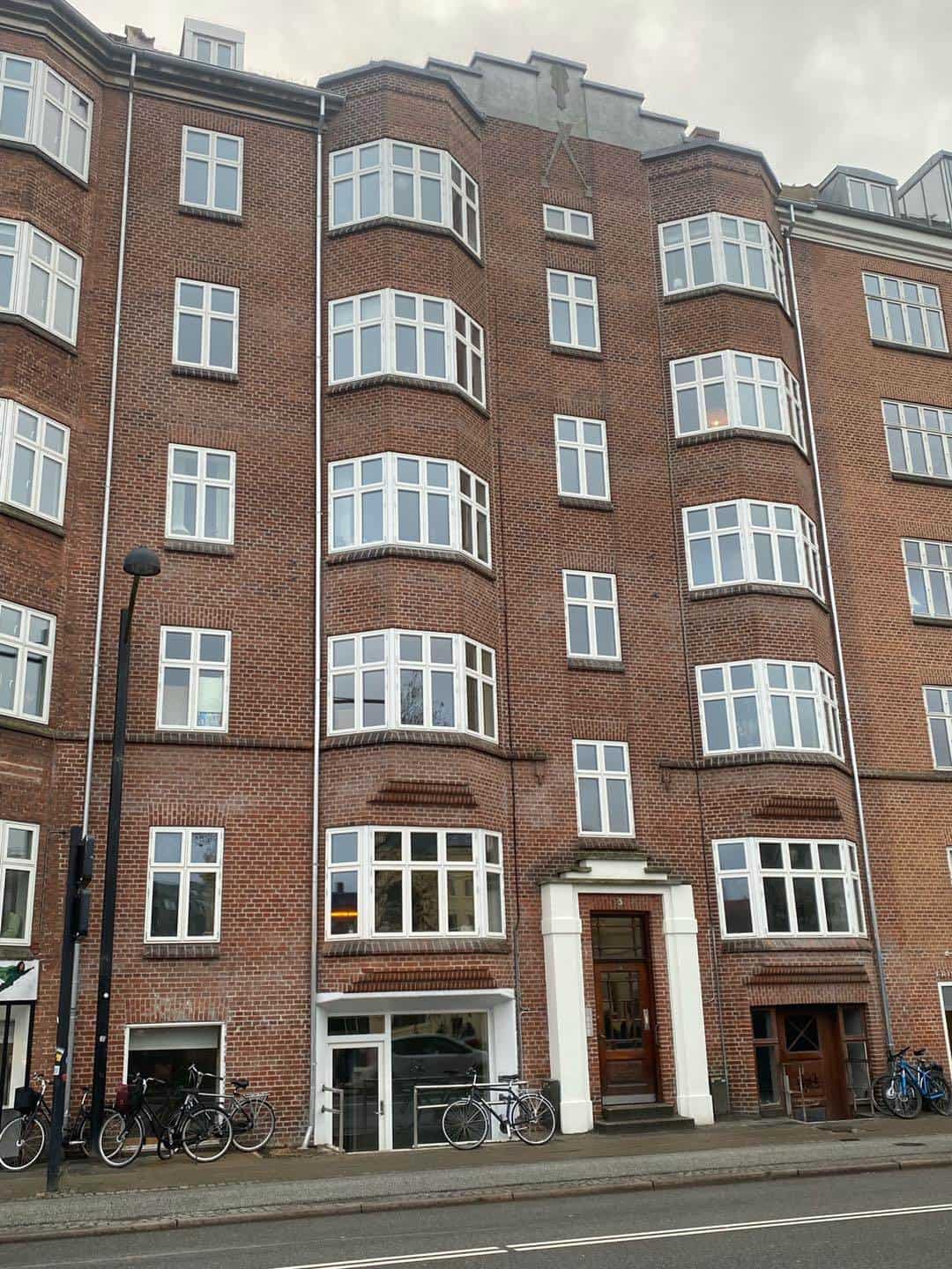 Renovering af ældre ejendom i Aarhus med nyt træværk og facadereparation.