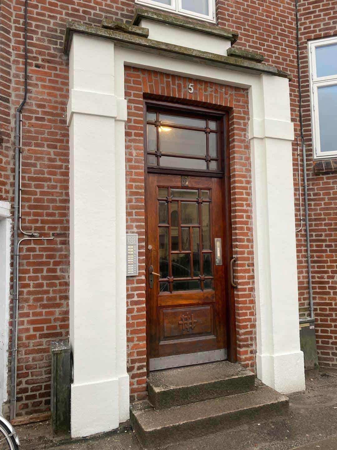 Klassisk træindgangsdør med glasparti i renoveret ejendom i Aarhus.
