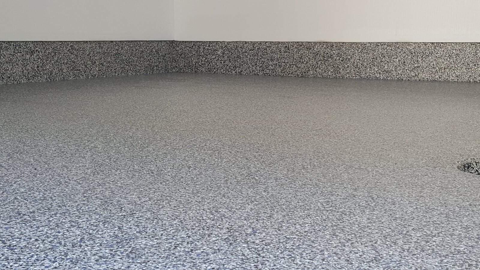 A newly finished room shows J&P Coatings’ strong, smooth epoxy floor and baseboards. The space feels clean and ready for use.