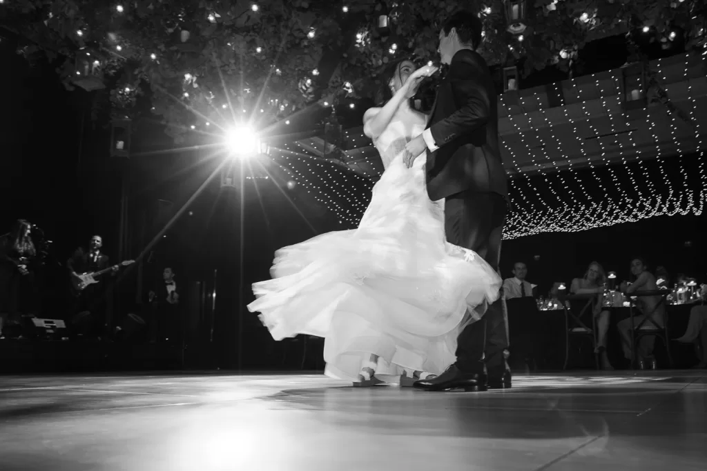 Southpointe ballroom showing the bride and groom on the dance floor, lucky devils band in the background, dancing in motion with twinkly fairy lights overhead