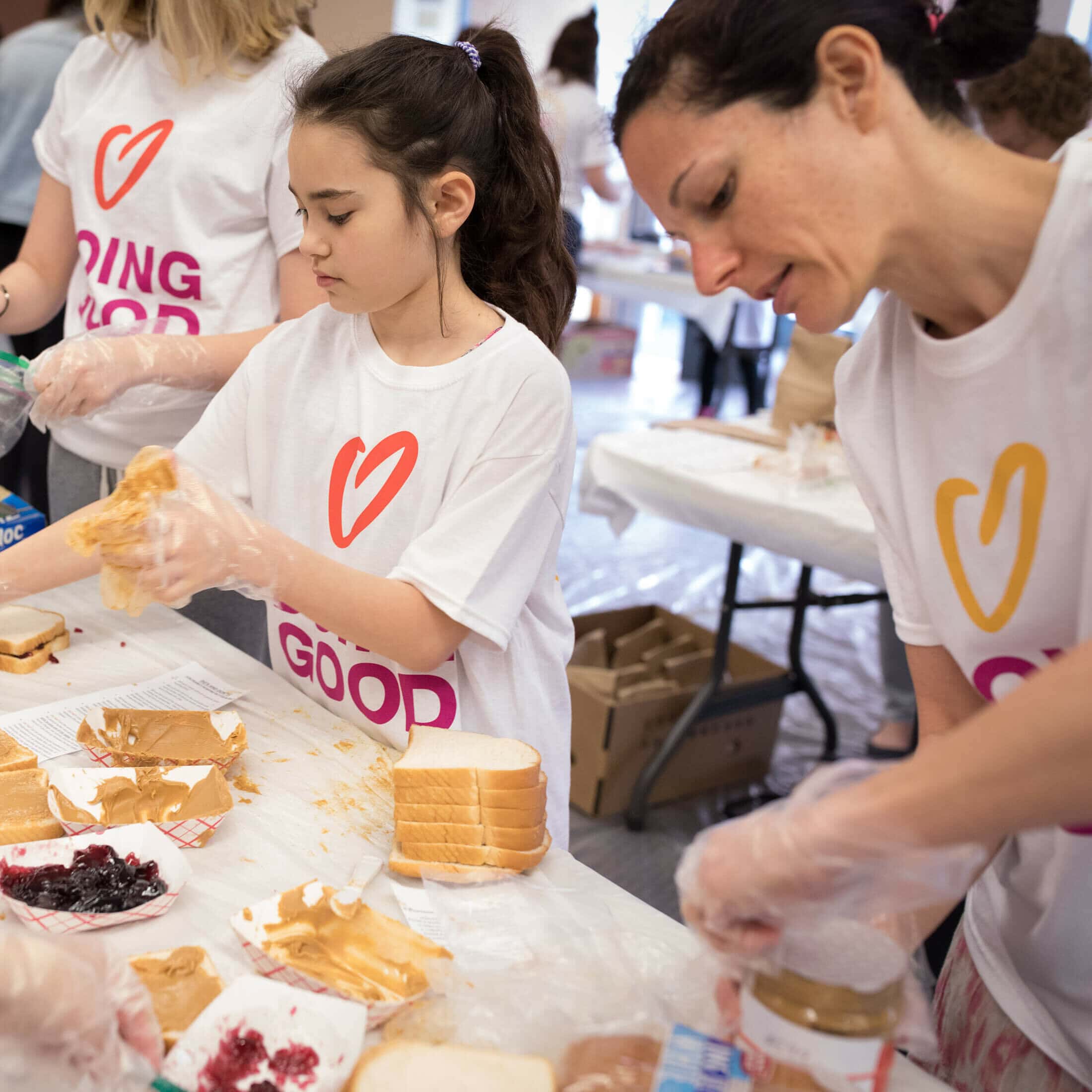 A group of kids making peanut butter and jelly sandwiches.