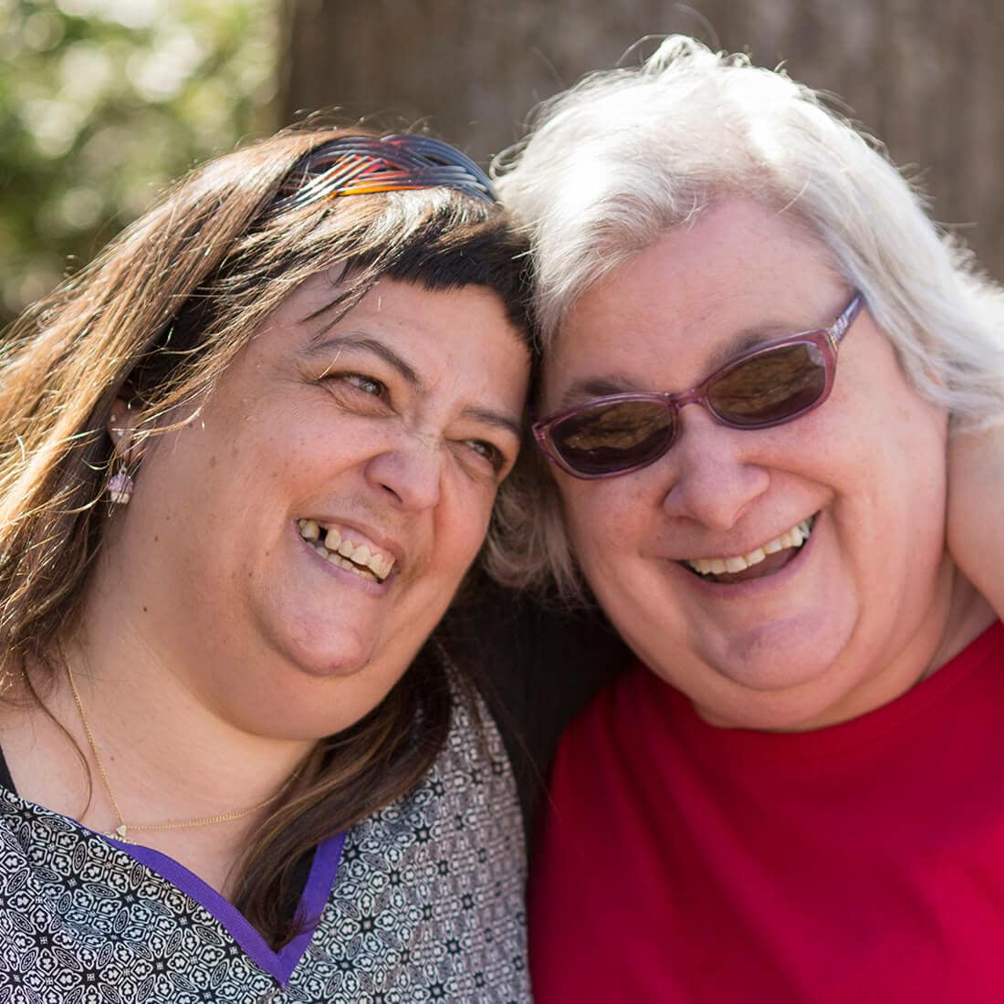 Two Women Hugging and Laughing|Jewish Residential Services Logo