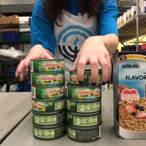 Volunteer with cans of tuna at Food Pantry