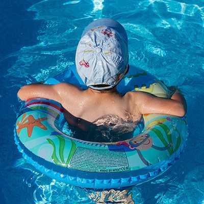 child in pool with floatation ring