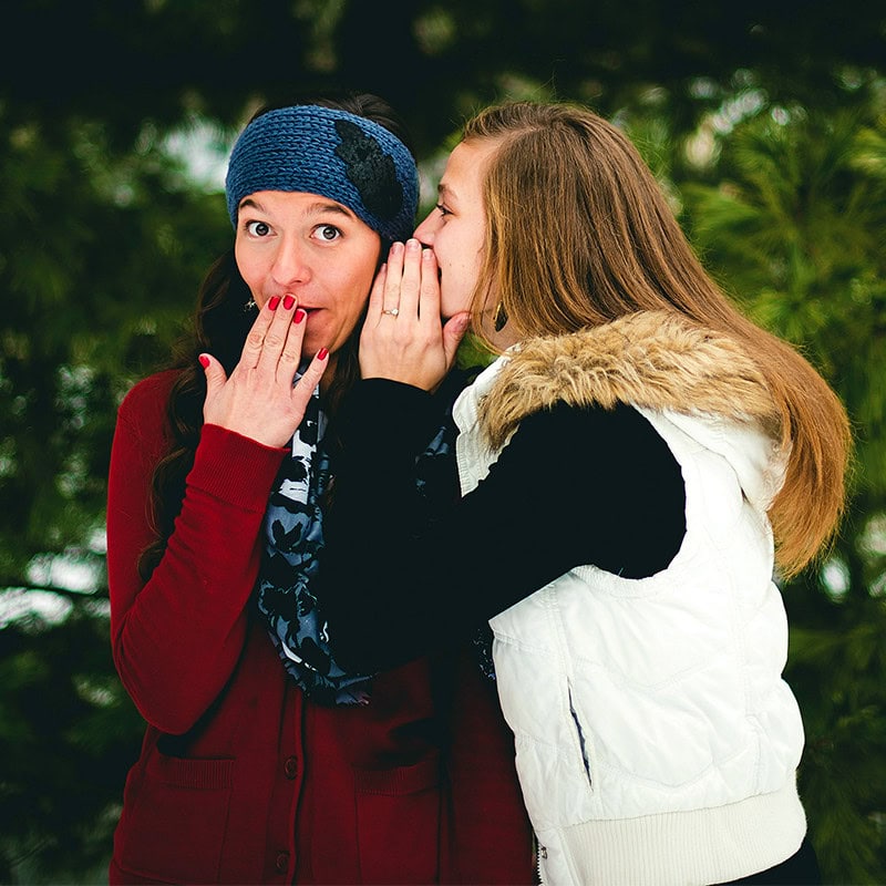 two women whispering gossip rumors