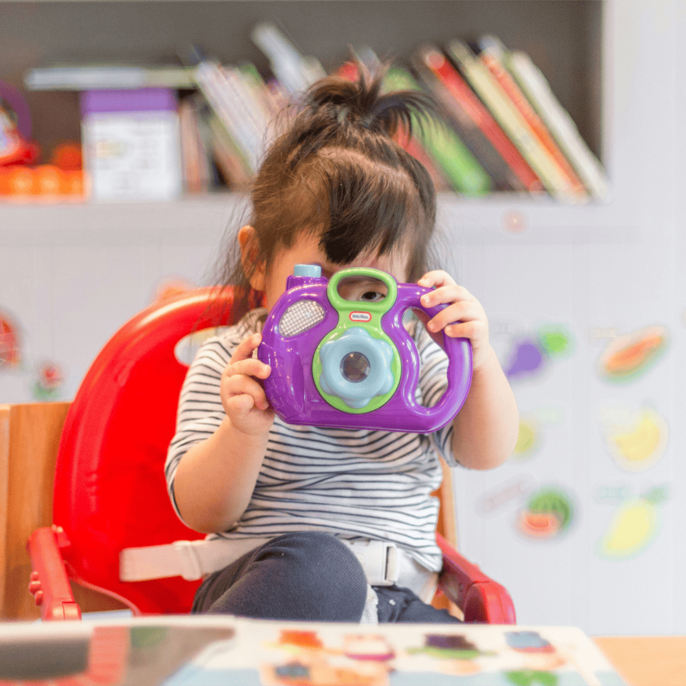 preschooler taking a photo on toy camera