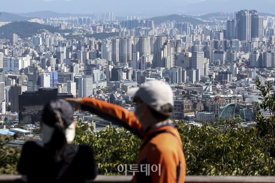 부동산 중개업소 매물 안내문과 아파트 단지 — 호가와 실거래가 차이를 보여주는 장면