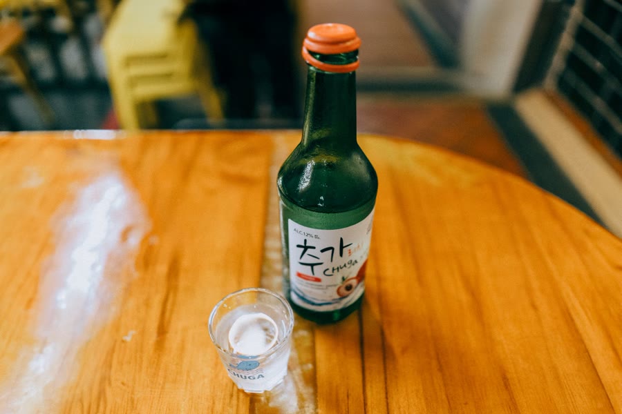 새벽 식당 테이블에 놓인 술병과 빈 자리 — 사람 없음