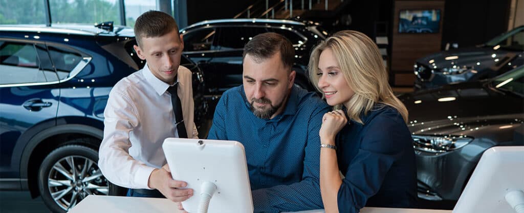 High-quality automotive sales consultation at car dealership with family buying new vehicle for excellent customer service and expert advice.