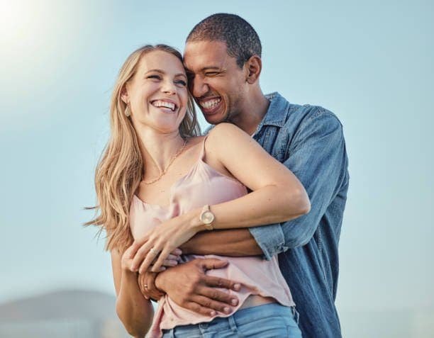 Happy couple embracing outdoors for relationship support.