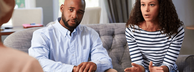 Counseling session with a therapist and clients discussing mental health.