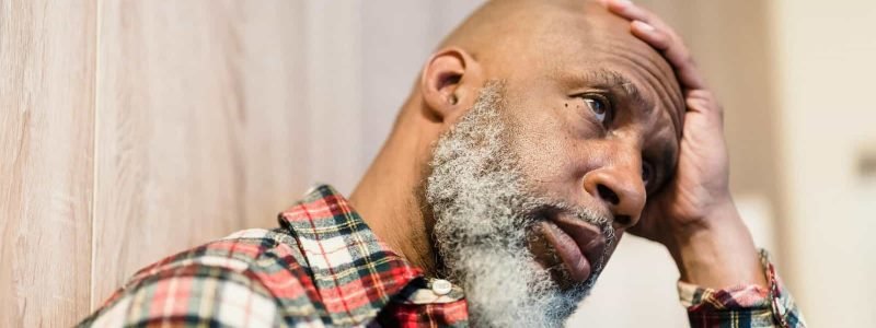 Stress and frustration in a middle-aged man with a beard, sitting indoors.