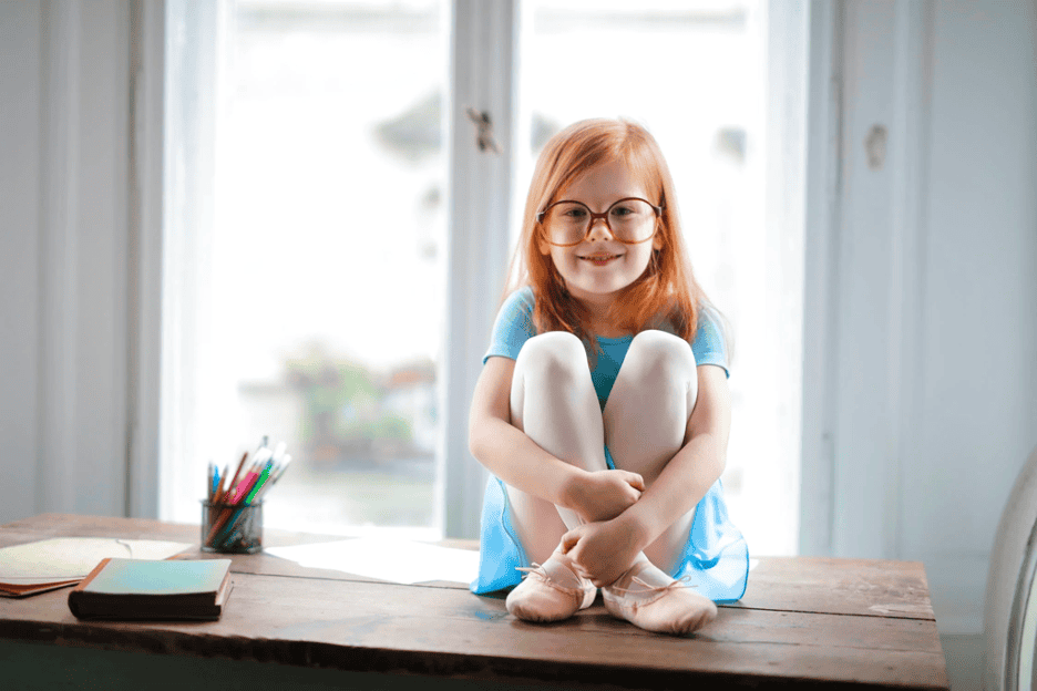 girl with crossed legs sitting on table