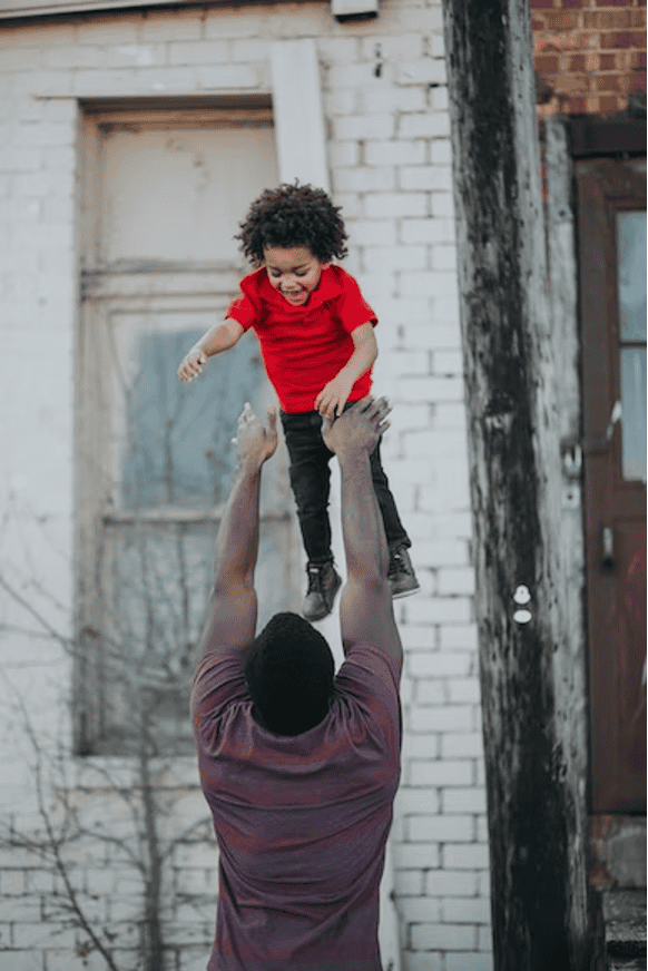 child being playfully thrown in the air and enjoying it