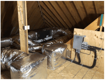 Attic space with HVAC system, featuring insulated ductwork and electrical components mounted on plywood walls and beams.