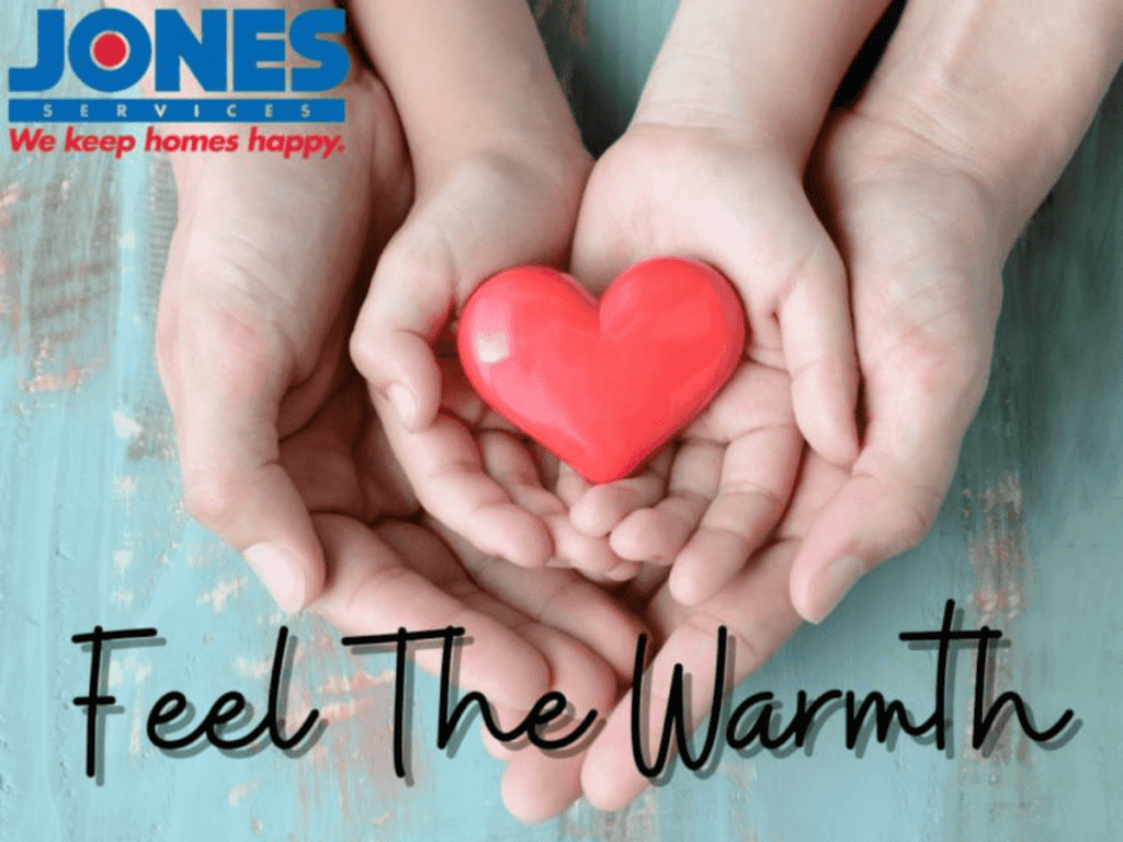 Hands holding a red heart-shaped object on a teal surface, with the text "Feel The Warmth" and "JONES SERVICES We keep homes happy" in the corner.