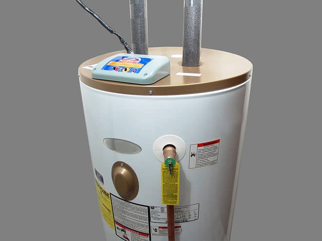 A cylindrical water heater with two pipes on top and a digital control panel. Various labels and warnings are visible.