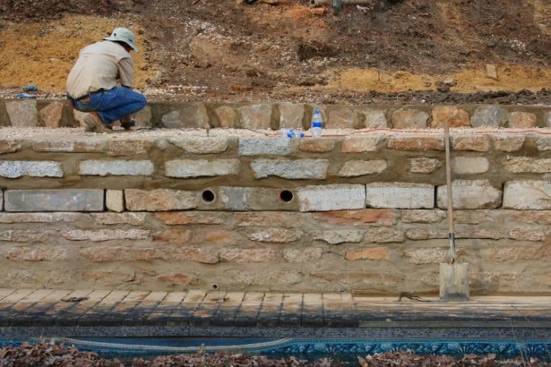 Natural stone retaining wall construction for landscape design by John Russell Landscape Architect, showcasing durable masonry skills and outdoor hardscape craftsmanship.