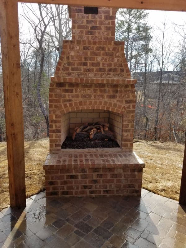 Vintage brick outdoor fireplace with chimney, perfect for backyard gatherings and outdoor lounging, designed by John Russell Landscape Architect.