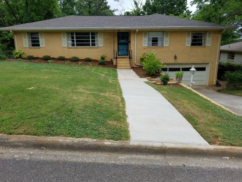 New residential landscaping by John Russell Landscape Architect featuring a well-maintained lawn, modern driveway, and landscape design in front of a single-family home.
