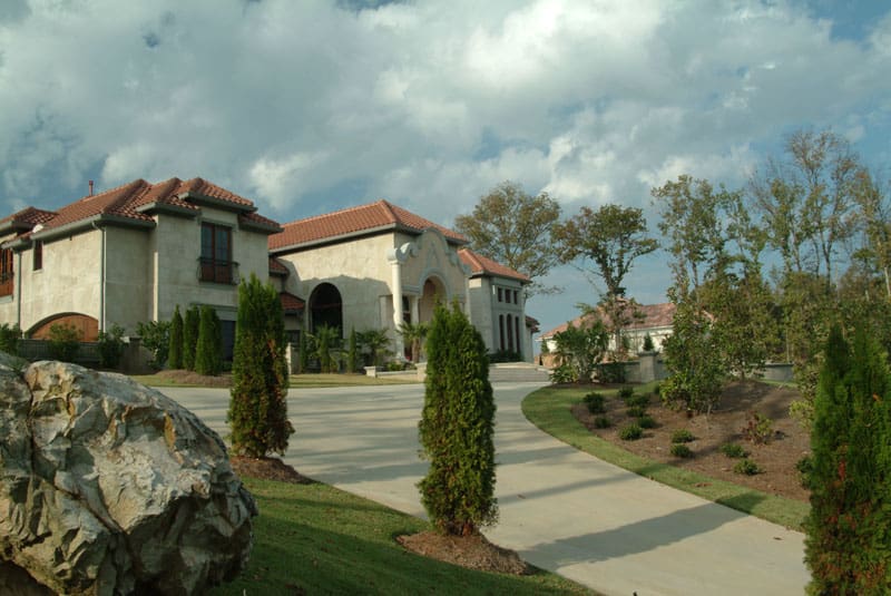 Luxurious residential landscape design by John Russell Landscape Architect featuring elegant home exterior and well-manicured yards with trees and shrubs.