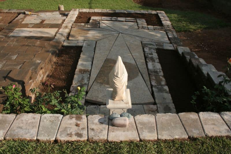 Stone garden fountain with statue and brick border, landscape design by John Russell Landscape Architect.